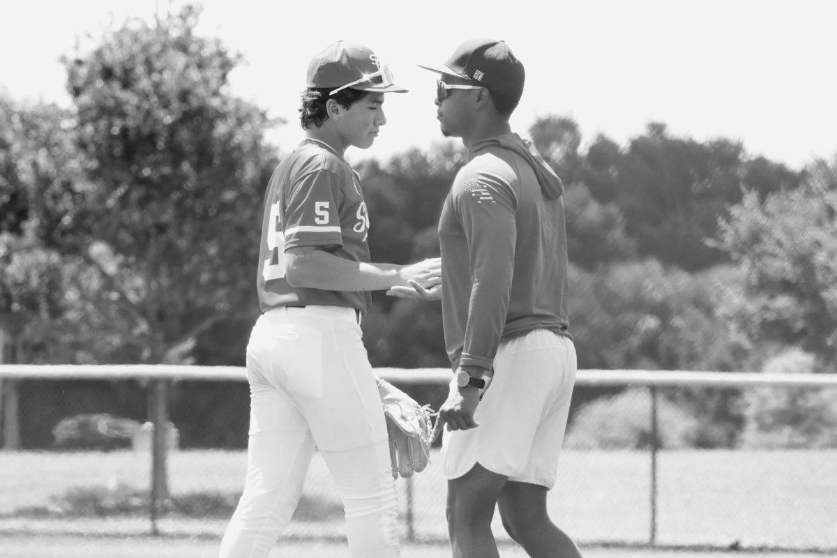 Chris Domenech shakes hands with his coach.