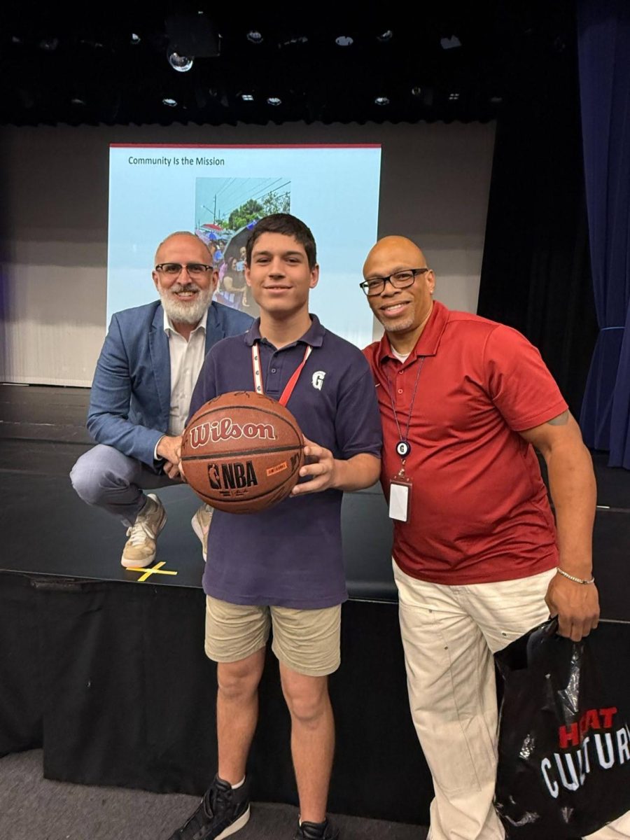 Smiles all around as eighth grader Gavin Steckler receives his signed NBA basketball from the Heat team.